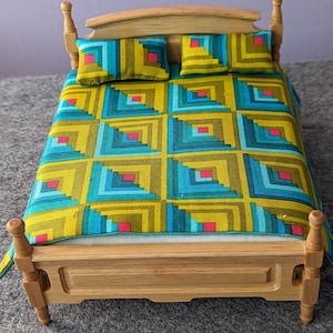 May include: A small wooden bed with a patterned quilt and pillows. The quilt has a geometric design in green, blue, and pink. The bed frame is made of light-coloured wood.