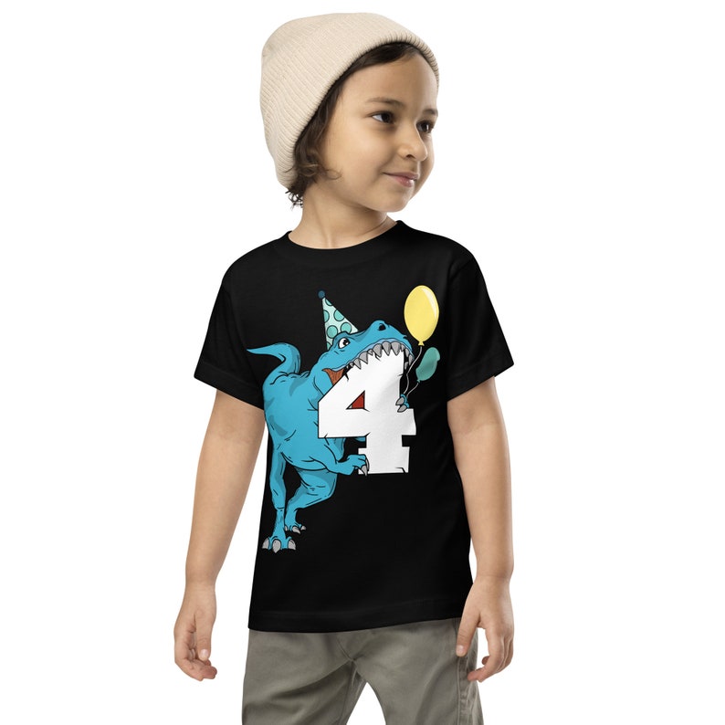 May include: A black t-shirt with a blue dinosaur wearing a party hat and holding a yellow balloon. The dinosaur is biting into a white number four. The text on the shirt says "4".