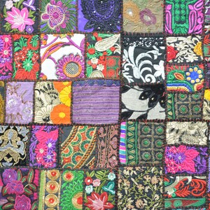 May include: A colorful patchwork quilt with various floral and geometric patterns in shades of purple, green, red, orange, and black.