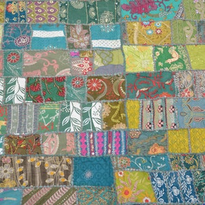 Peut inclure: Une courtepointe patchwork colorée avec une variété de motifs floraux et géométriques dans des tons de vert, bleu, rouge et jaune.