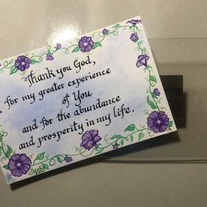 May include: A handwritten note with a floral border and the text "Thank you God, for my greater experience of You and for the abundance and prosperity in my life."