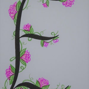 May include: A black calligraphic letter E with a vine and pink roses wrapping around it. The background is white.
