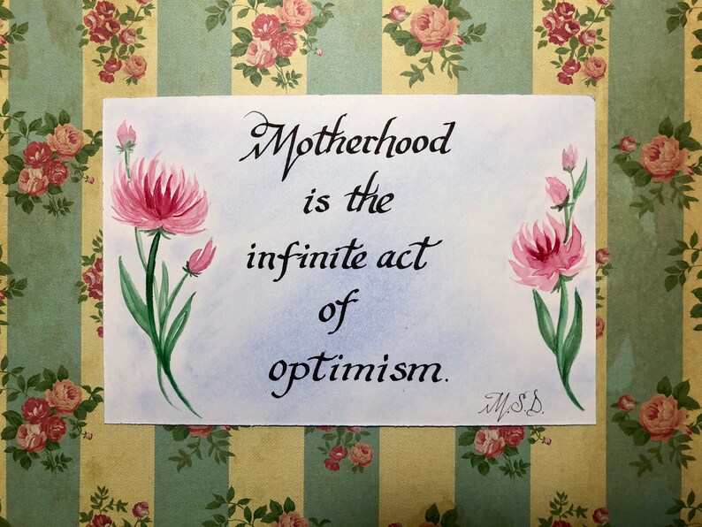 May include: A watercolor painting of pink flowers with green stems on a light blue background. The quote "Motherhood is the infinite act of optimism." is written in black calligraphy with the signature "M.S.D." below.