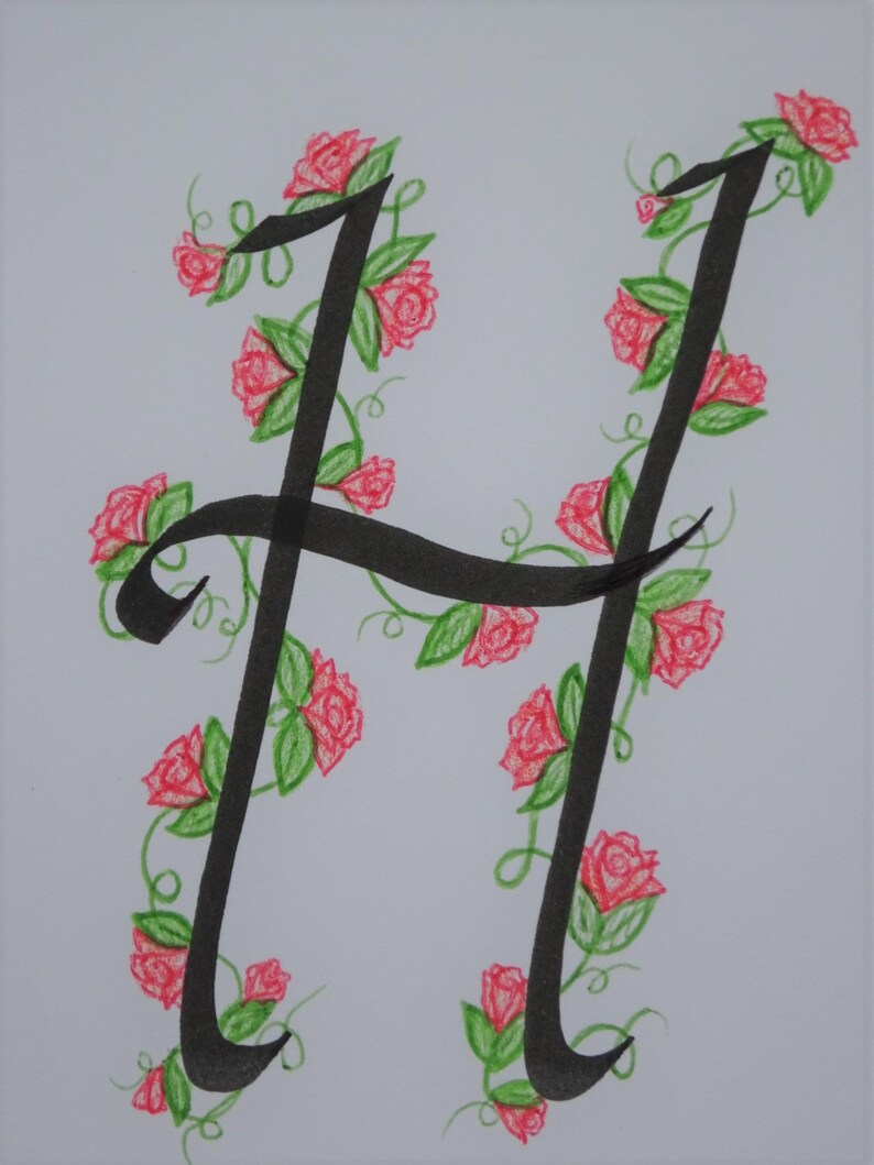 May include: A black calligraphy letter H with a vine of pink roses and green leaves around it.