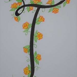 May include: A black calligraphic letter T with a vine of orange roses and green leaves winding around it.