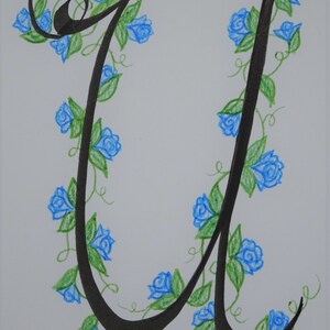 May include: A black calligraphic letter U with a vine of blue flowers and green leaves wrapping around it.