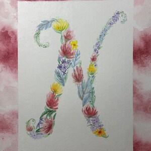 May include: Watercolor painting of the letter N made up of flowers in shades of pink, purple, yellow, and blue.