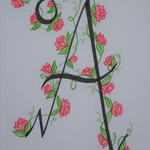May include: A black calligraphic letter A with a vine of red roses and green leaves winding around it.