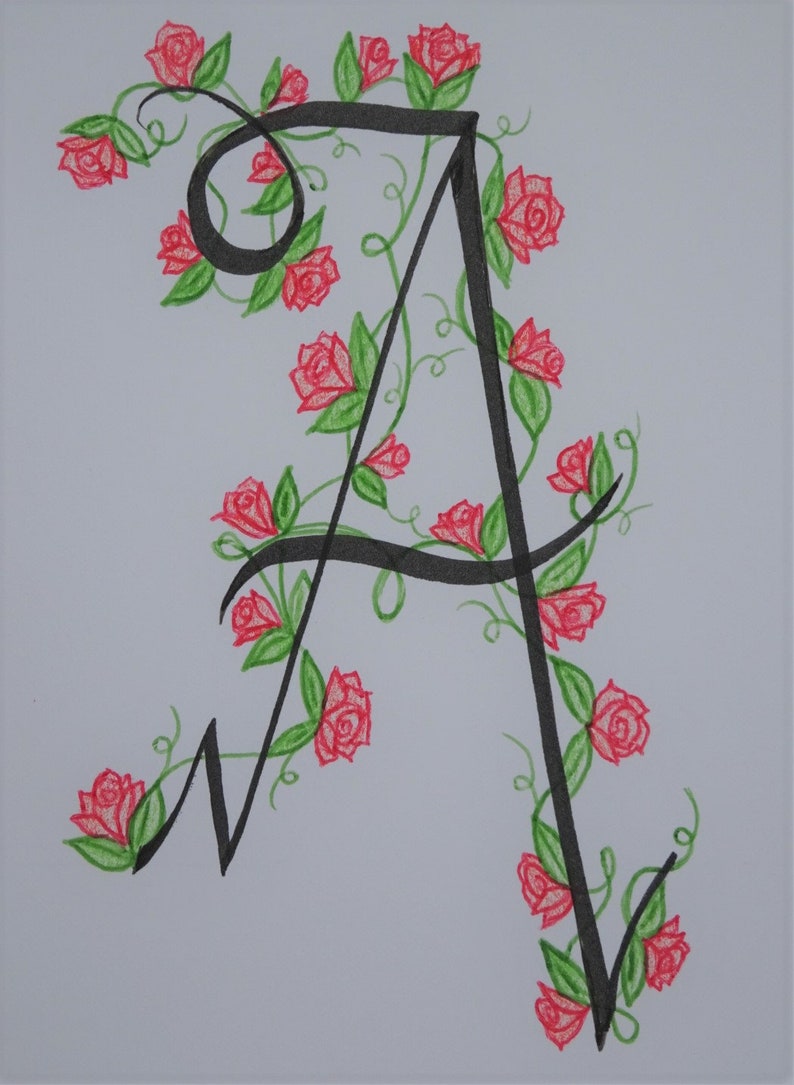May include: A black calligraphic letter A with a vine of red roses and green leaves winding around it.