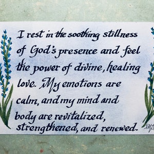 May include: A handwritten quote about finding peace and healing in God's presence. The quote is written in black ink on a white background with blue and green floral illustrations on either side. The quote reads: "I rest in the soothing stillness of God's presence and feel the power of divine, healing love. My emotions are calm, and my mind and body are revitalized, strengthened, and renewed."