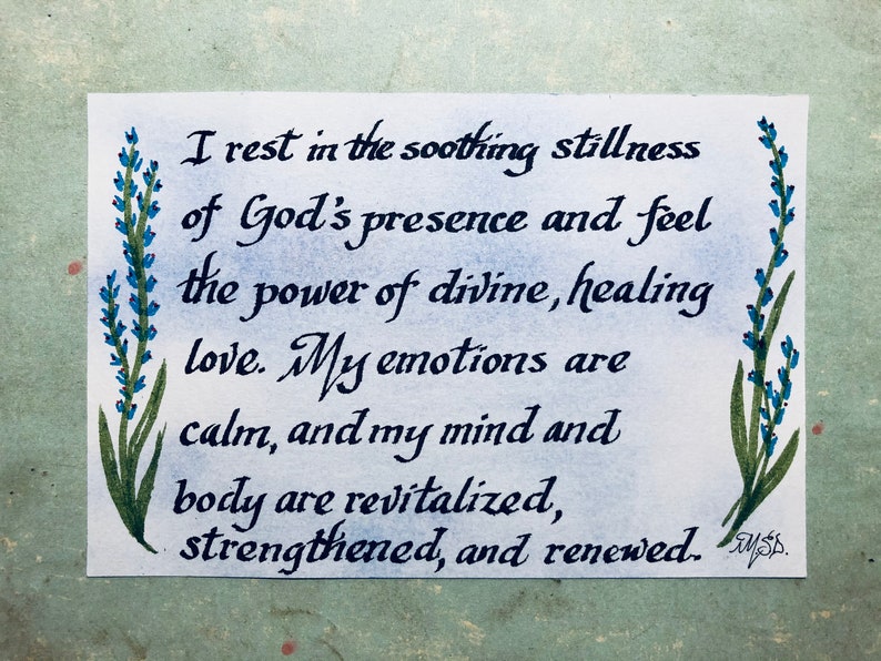 May include: A handwritten quote about finding peace and healing in God's presence. The quote is written in black ink on a white background with blue and green floral illustrations on either side. The quote reads: "I rest in the soothing stillness of God's presence and feel the power of divine, healing love. My emotions are calm, and my mind and body are revitalized, strengthened, and renewed."