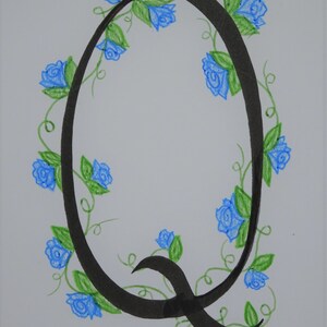 May include: A black calligraphic letter Q with a decorative border of blue roses and green vines.