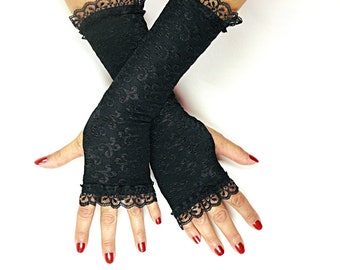 May include: A pair of black fingerless gloves with lace trim. The gloves are made of a stretchy, sheer fabric and have a floral pattern.