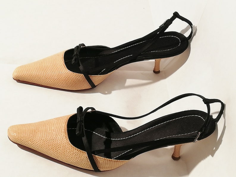 Puede incluir: Un par de zapatos de tac&oacute;n beige con correa trasera y un patr&oacute;n texturizado. Los zapatos tienen punta afilada, detalles en negro y un tac&oacute;n peque&ntilde;o. Los tacones miden aproximadamente 5 cm.
