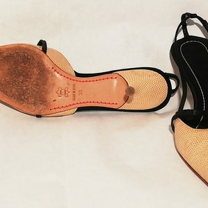 Puede incluir: Par de zapatos de tac&oacute;n slingback beige y negro con punta. Los zapatos tienen un patr&oacute;n texturizado en las secciones beige y una correa negra. Las suelas son de cuero con costuras rojas y un tac&oacute;n peque&ntilde;o. Talla 38.