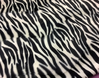 Peut inclure: Tissu à imprimé zèbre noir et blanc avec une texture douce et duveteuse.