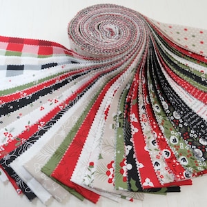 May include: A fabric roll with a variety of Christmas-themed patterns. The fabrics include red, green, black, and white designs with floral, plaid, and dotted patterns. The fabrics are arranged in a fan shape.