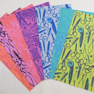 May include: A selection of fabric swatches in a fan arrangement, featuring sewing-themed patterns. The designs include scissors, rotary cutters, needles, and other tools in pink, orange, purple, blue, and green. Each swatch has a serged edge.