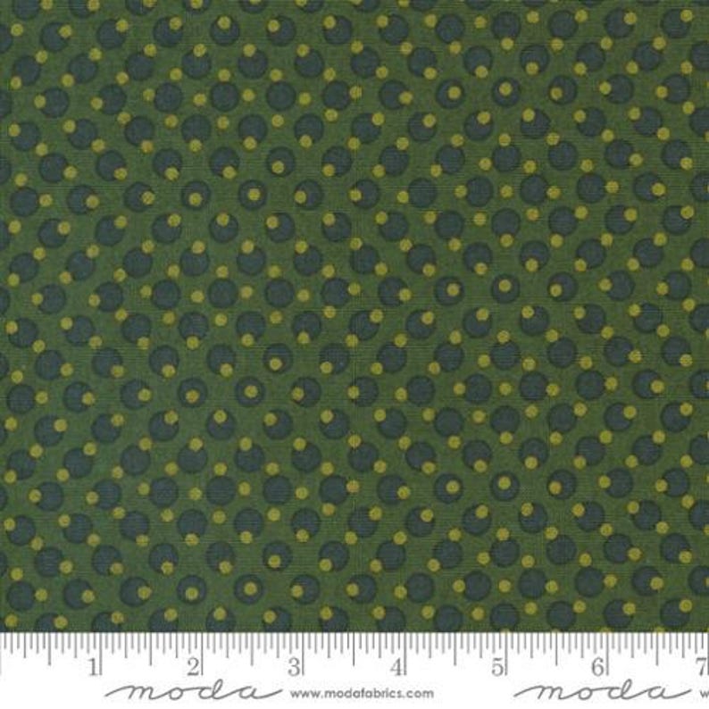 Peut inclure: Tissu vert avec un motif r&eacute;p&eacute;titif de cercles bleu fonc&eacute; avec des centres jaunes. Le tissu a un aspect textur&eacute; et une r&egrave;gle est en bas. Le mot "moda" est imprim&eacute; sur la r&egrave;gle.