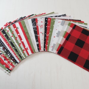 May include: A selection of fabric squares in diverse patterns and colours, including red and black buffalo check, floral, and striped designs. The fabric pieces are arranged in a fan shape, displaying the variety of prints.