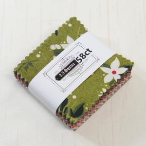 Op de afbeelding: Een stapel stoffen vierkanten, elke zijde meet 6,35 cm, verpakt met een witte band. De stof heeft een groene achtergrond met witte bloemen en rode accenten. De band leest "2.5 Square - 58ct" in een decoratief kader.