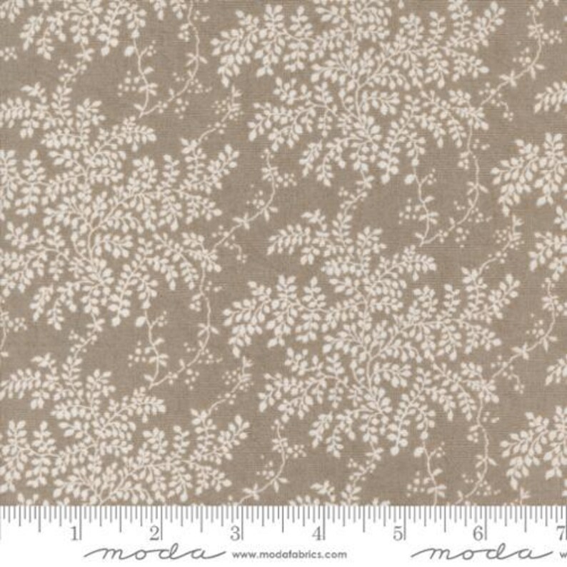 Peut inclure: Tissu beige avec un motif r&eacute;p&eacute;t&eacute; de feuilles et de vignes blanches. Les feuilles sont d&eacute;taill&eacute;es et cr&eacute;ent un design naturel et organique. Id&eacute;al pour le patchwork, la couture et divers projets d'artisanat.