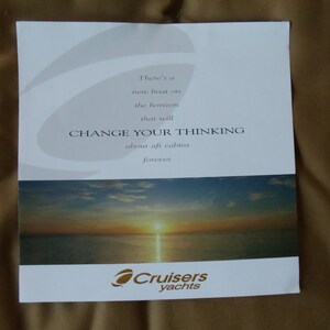 May include: A white brochure with a sunset image and the text "There's a new boat on the horizon that will CHANGE YOUR THINKING about aft cabins forever." The brochure also features the logo "Cruisers yachts".