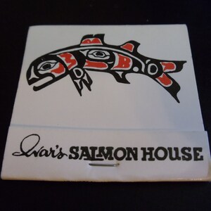 May include: A white matchbook with a black and red stylized salmon design and the text " Ivar's SALMON HOUSE ".