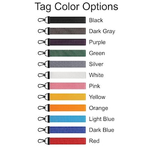 May include: Image showing a variety of tag color options. Each tag is a different color, including black, dark gray, purple, green, silver, white, pink, yellow, orange, light blue, dark blue, and red. Each tag has a black metal clasp.