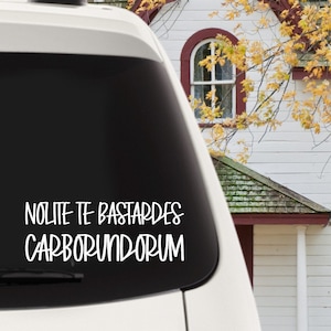 Peut inclure: Une voiture blanche avec une lunette arrière noire et un autocollant en vinyle blanc qui dit "Nolte Te Bastardes Carborundum".