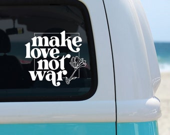 Może przedstawiać: Biało-turkusowy zabytkowy van z naklejką na oknie z napisem "make love not war" w stylizowanej czcionce. Obok tekstu znajduje się ilustracja kwiatowa. Van jest zaparkowany na piaszczystej plaży z widocznym w tle oceanem.