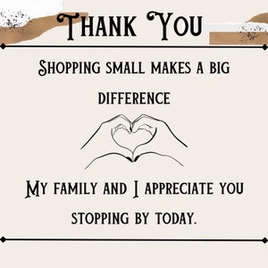May include: A beige card with black text that reads "THANK YOU." Below, it says "SHOPPING SMALL MAKES A BIG DIFFERENCE." A line drawing of hands forming a heart is in the center. The text "MY FAMILY AND I APPRECIATE YOU STOPPING BY TODAY" is at the bottom.