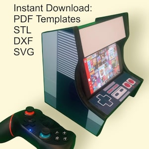May include: A miniature arcade cabinet with a screen displaying video game graphics. The cabinet is black, blue, and gray, with a controller in the foreground. Text on the image reads "Instant Download: PDF Templates STL DXF SVG."