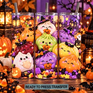 May include: A cylindrical tumbler with a metal straw featuring a colorful Halloween pattern of smiling dumpling characters wearing witch hats, surrounded by pumpkins, candy corn, and a spooky house silhouette against a purple night sky.