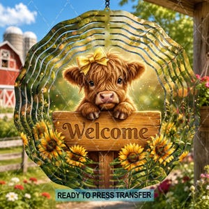 May include: A circular metal wind spinner featuring a fluffy Highland calf with a yellow bow on its head, resting its paws on a wooden sign that reads Welcome. The design includes sunflowers and a background of a red barn and green fields.