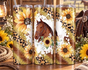 May include: Three cylindrical tumblers with metal straws featuring a brown horse head, yellow sunflowers, and a black and tan leopard print pattern over a rustic wood grain background with gold glitter accents. The text reads READY TO PRESS TRANSFER.