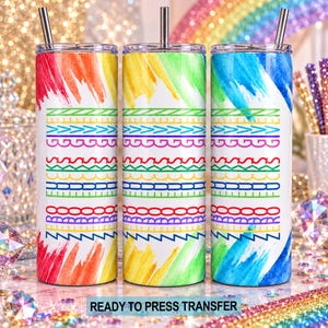 May include: Three cylindrical tumblers with metal straws, featuring a white background with rainbow watercolor brushstrokes at the top and bottom. The center displays horizontal rows of colorful geometric patterns and the text ZERO FUCKS GIVEN.
