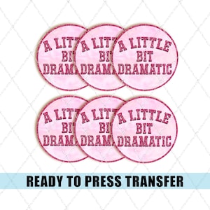 May include: Six pink circular transfers with the text "A Little Bit Dramatic" in a dark pink font. The transfers have a glittery border and a textured background. The phrase "Ready to Press Transfer" is at the bottom.