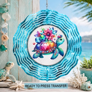 May include: A circular metal wind spinner featuring a central graphic of a sea turtle with a shell made of colorful faceted gemstones and a large pink flower on its back. The outer edge has a wavy blue pattern. Text reads READY TO PRESS TRANSFER.