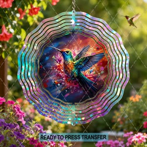 May include: A circular metal wind spinner featuring a vibrant, multi-colored hummingbird in flight at the center. The design includes iridescent, wavy concentric rings that create a shimmering effect, set against a background of colorful flowers.