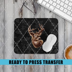 May include: A ready to press heat transfer design featuring a brown and white deer head with antlers on a black and gray camouflage background.