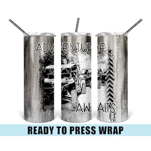 May include: A white tumbler with a wood grain pattern and black and white graphic of off-road vehicles. The text "Adventure Awaits" is printed on the tumbler.