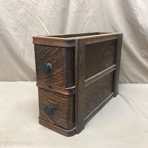 Early turn of the century treadle sewing machine side shelf with drawers.