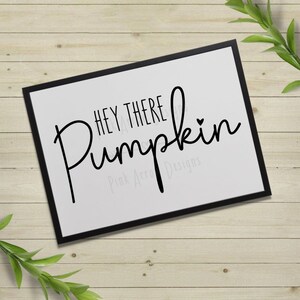 May include: A black and white printable sign with the text "Hey There Pumpkin" in a cursive font. The text is centered on a white background with a small heart symbol after the word "Pumpkin".