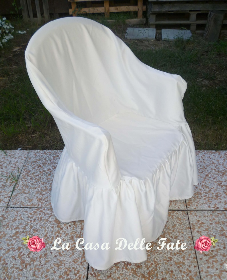 May include: White chair cover with a ruffled bottom. The cover is made of a soft, white fabric and has a simple, elegant design.