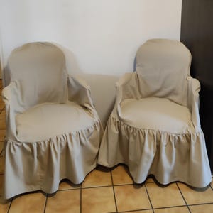Peut inclure: Deux housses de chaise beige à volants. Les housses sont en tissu doux et léger et ont un design simple et élégant.