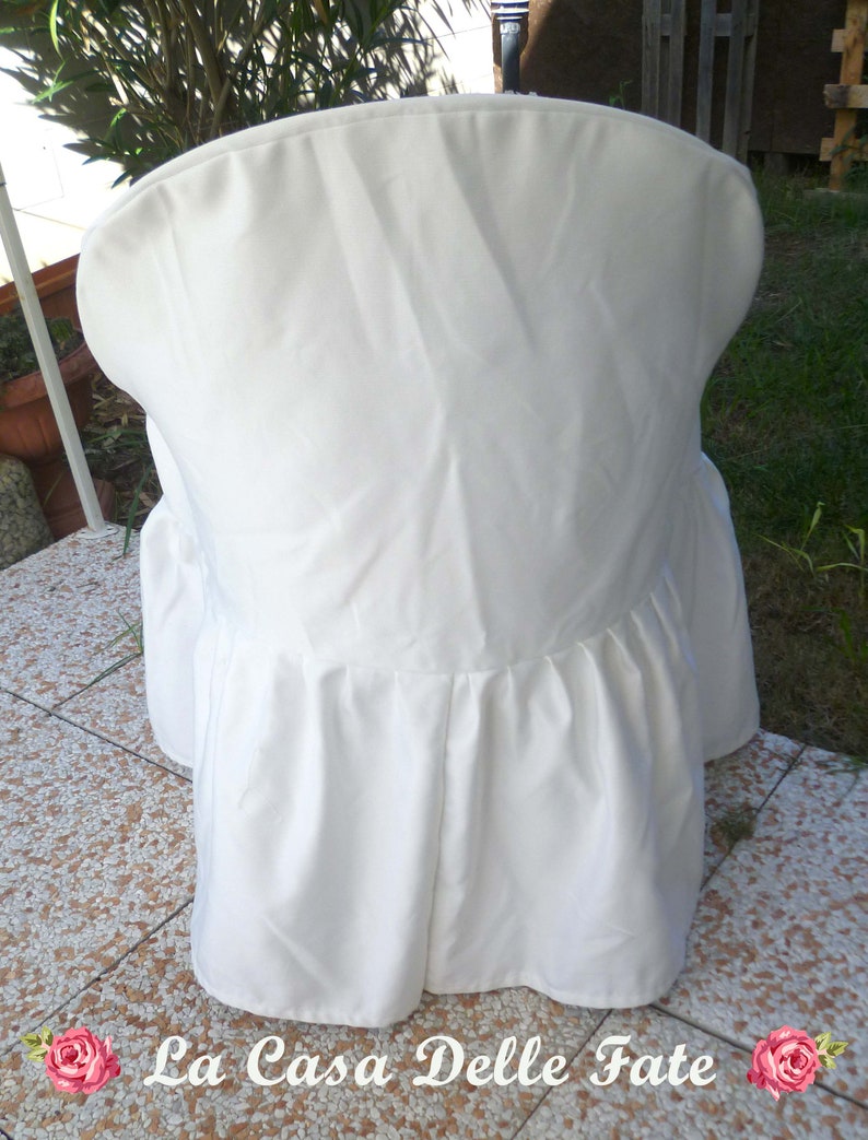 May include: White chair cover with a ruffled bottom. The cover is made of a smooth, white fabric.