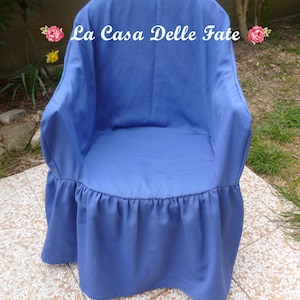 May include: A blue chair cover with a ruffled bottom. The cover has the text "La Casa Delle Fate" printed on the back.