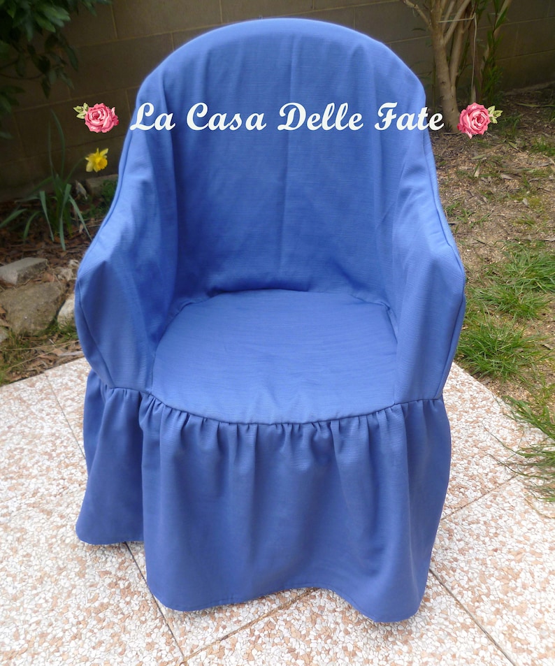 May include: A blue chair cover with a ruffled bottom. The cover has the text "La Casa Delle Fate" printed on the back.