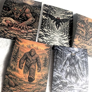 Może przedstawiać: Pięć prostokątnych wydruków z ilustracjami dark fantasy. Jeden przedstawia wilkołaka, drugi ćmopodobne stworzenie w zaśnieżonym lesie, trzeci skrzydlatego demona, czwarty sasquatcha w górskim krajobrazie, a piąty szkieletową postać przypominającą jelenia.